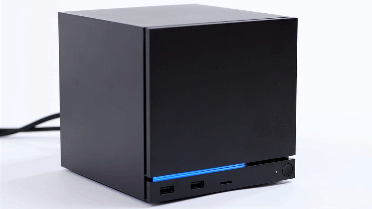 Valve Steam Machine console hardware sitting on a desk with a Steam Controller